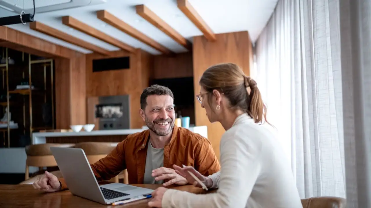 Mature couple talking and using the laptop at home