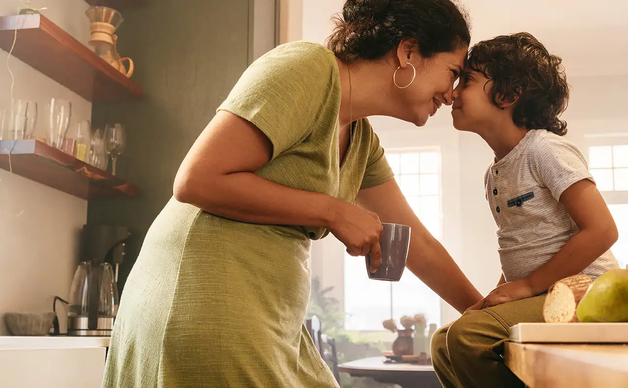 a woman and a child in a kitchen.