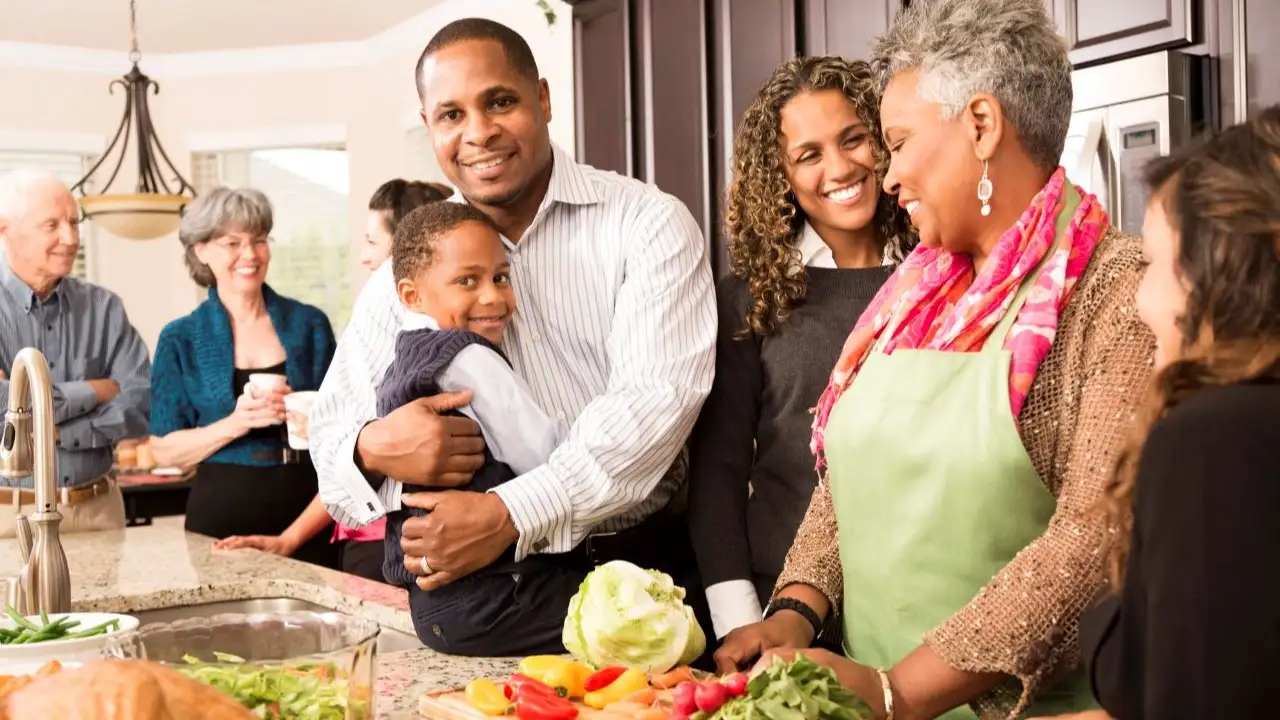 Family, friends and neighbors gather together in senior woman's home to prepare Thanksgiving dinner. 