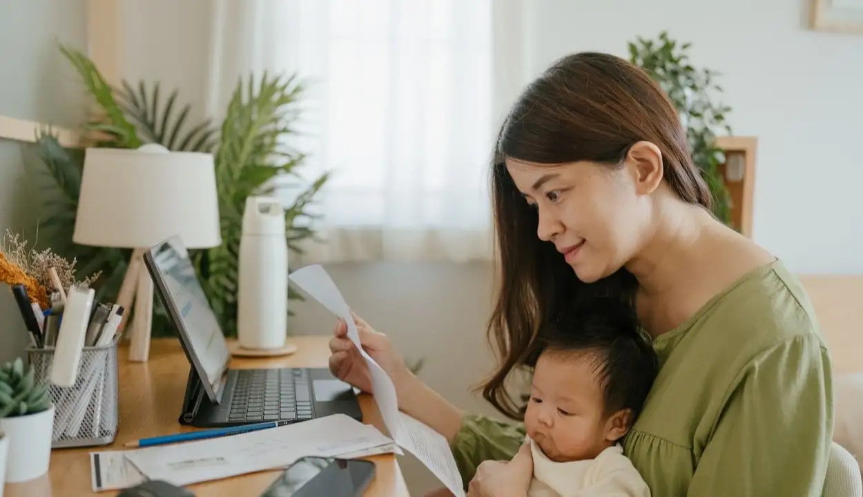 Woman holding paper various expense bills and plans for personal finances at her home.