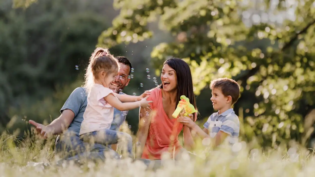 Happy parents and their small kids spending a spring day in the forest