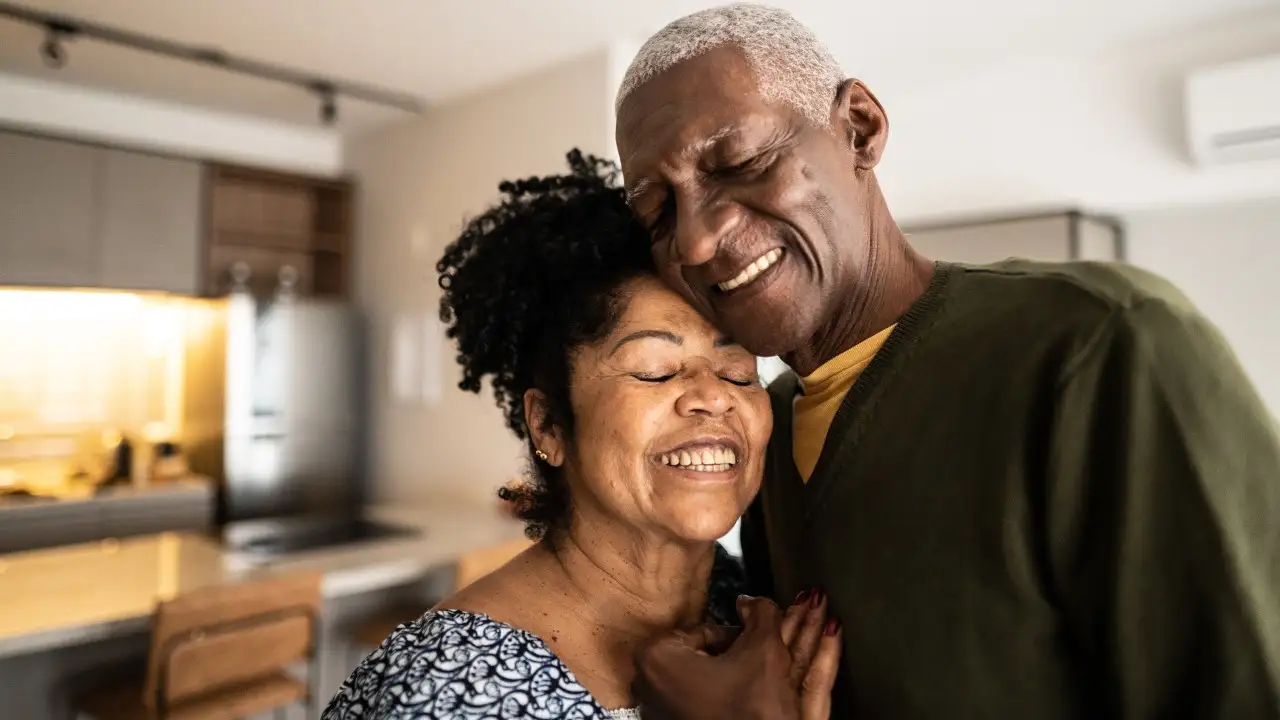 Senior couple embracing each other at home 