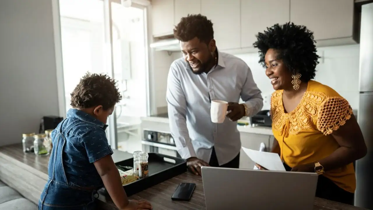 Family at home reunited in the kitchen in the morning while parents doing home finances