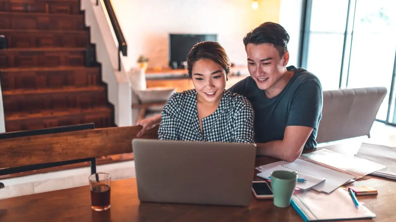 Young couple calculating monthly budget after paying off debt