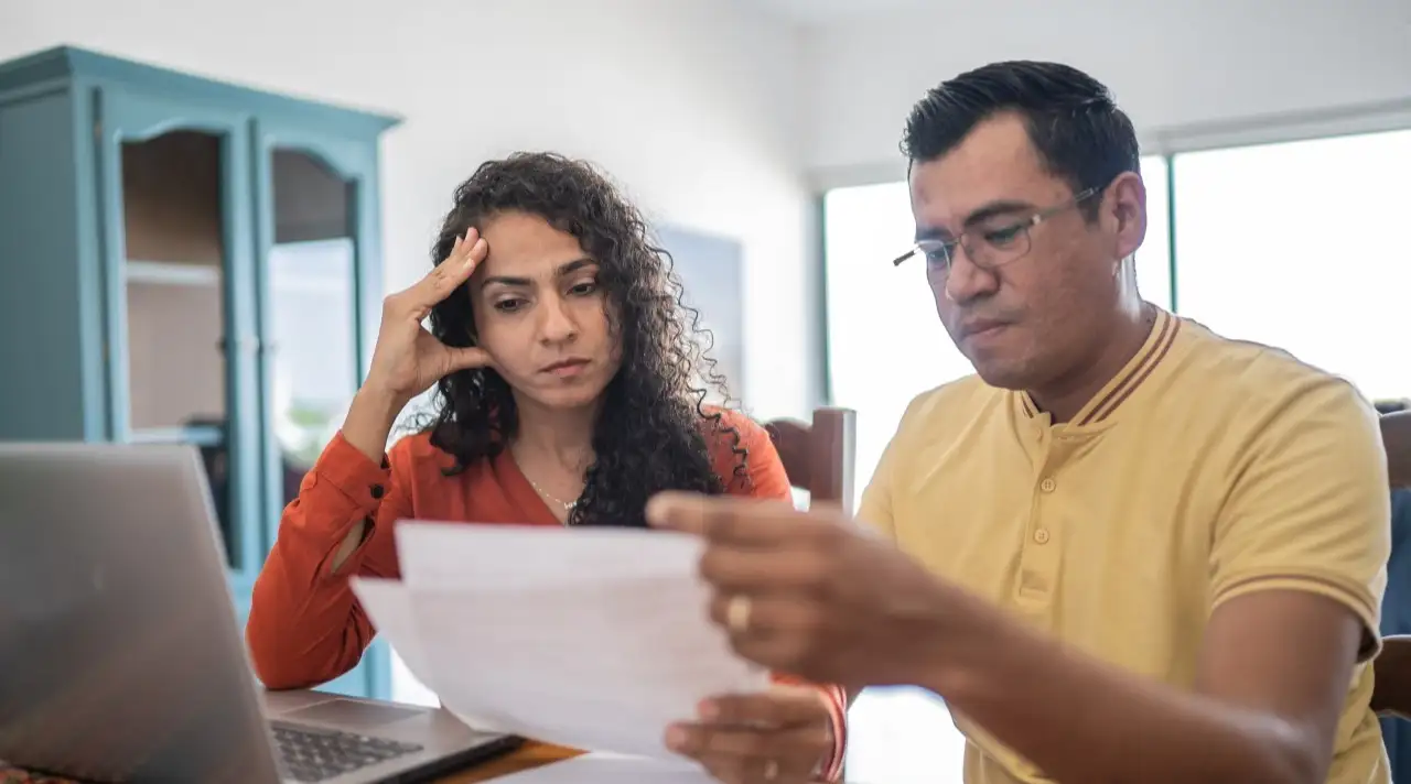 Worried couple using laptop doing home finances