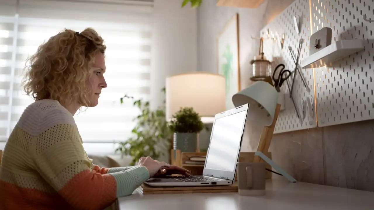 Side-view of woman looking at her laptop