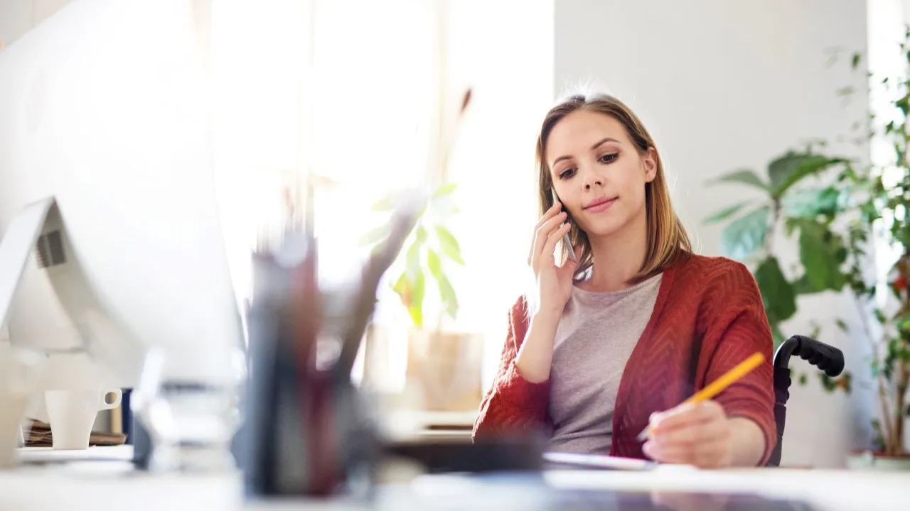 Young woman sitting at a desk dealing with debt stress